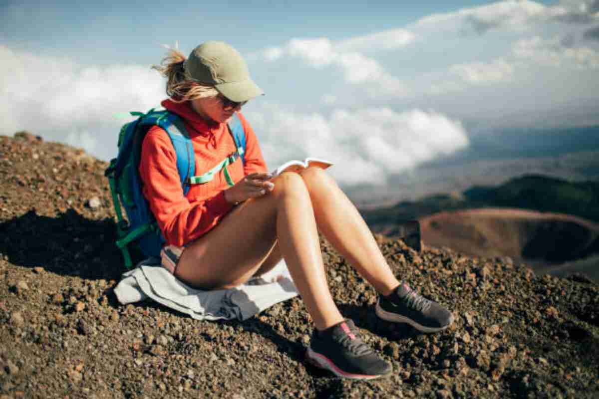 Ragazza legge un libro in montagna