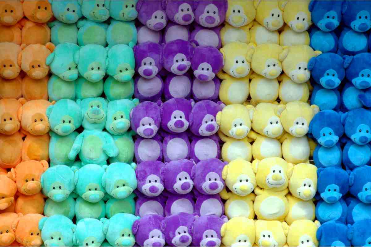 Tanti peluche alla parete di vari colori tutti in fila