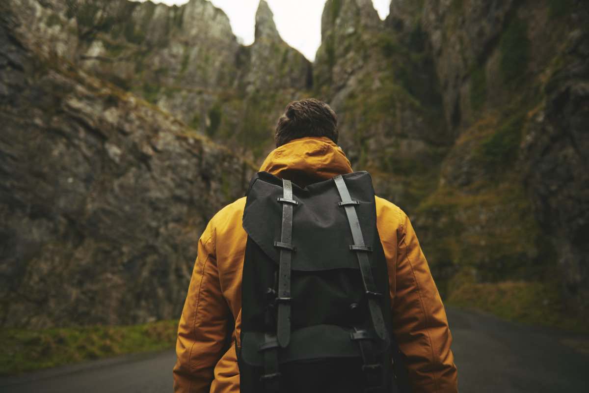 Un uomo con lo zaino fa trekking in montagna