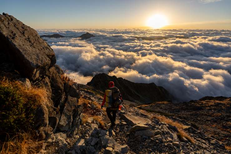 Escursionista ammira le nuvole e l'orizzonte da un sentiero di montagna