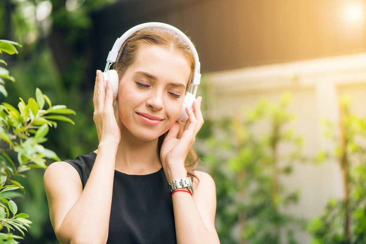 ragazza ascolta musica con sfondo naturale