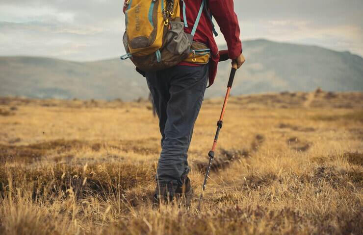 uomo cammina con bastoncini da trekking